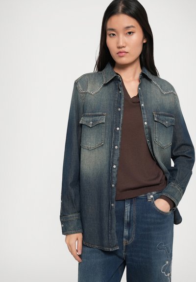 Denim overhemd met een verloop van donkerblauw naar lichtblauw, drukknopen, twee borstzakken en decoratieve stiksels langs de schoudernaad.