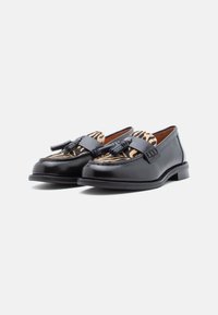Mocasini din piele neagră cu un superior din textile cu model, având un design cu dungi de zebra, detaliate cu franjuri și o talpă neagră rezistentă.