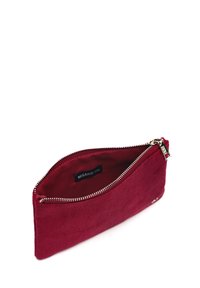 Červená kordurová taška s kovovým zipsom, vybavená hladkým vnútorným podšívkou a štítkom. Elegantný, predĺžený dizajn, ideálny na malé predmety.