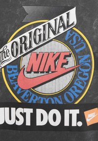 T-shirt grigia con diverse grafiche stampate, tra cui "the ORIGINAL" e "Nike" in rosso, con un logo circolare blu e giallo e il testo "JUST DO IT."