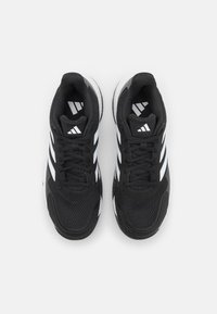 Chaussures de sport noires avec une tige en mesh, featuring trois rayures blanches. Bout arrondi et semelle texturée pour une meilleure traction.