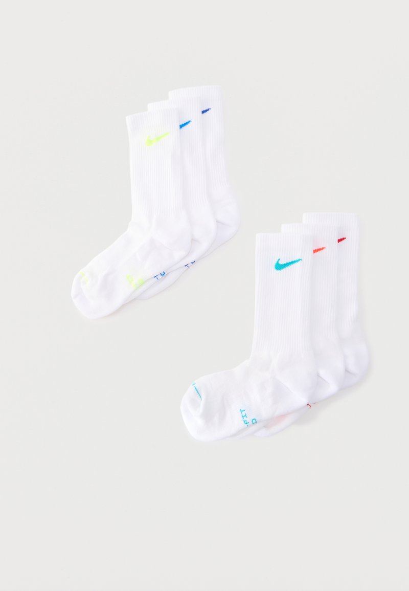 Sześć par białych skarpetek za kostkę z różnokolorowymi znakami Nike i pasującymi akcentami na palcach, ułożonych na jasnym tle.