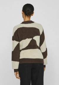 Flauschiger Pullover mit gestreiftem Muster in Braun und Creme. Verfügt über lange Ärmel, gerippte Bündchen und einen runden Halsausschnitt. Weicher Stoff.