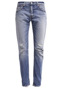 Vaaleansiniset farkut, joissa on slim fit -malli, kulutetut tahrat, epätasaiset lahkeet ja klassinen viiden taskun muotoilu.