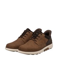 Chaussures en cuir marron à lacets avec une texture lisse, bout arrondi, accents sombres contrastants, et une semelle extérieure en caoutchouc blanche.