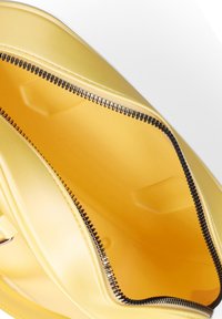 Borsa a cerniera gialla con un'esterno liscio e lucido e una cerniera nera a contrasto. L'interno è di un giallo più chiaro, senza motivi o decorazioni.
