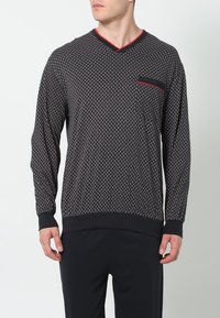 Langarm-V-Ausschnitt-Shirt in Schwarz mit geometrischem Muster, roten Akzenten an Kragen und Tasche sowie gerippten Bündchen und Saum.
