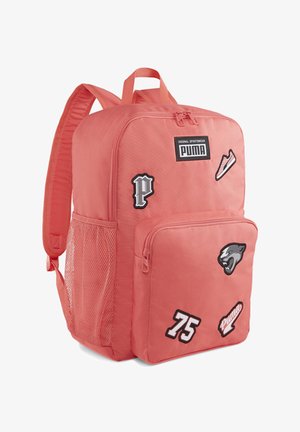 Sac à dos rose corail avec écussons du logo Puma, poche avant zippée, poche latérale en mesh et bretelles rembourrées.