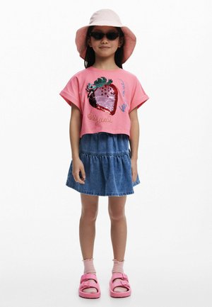 Rosa kurzärmliges Cropped-T-Shirt mit Erdbeeren aus Pailletten, Jeansrock, rosa Sandalen und passendem Bucket Hat. Glatte, lässige Textur.