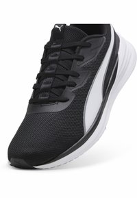 Zwarte sportieve schoen met bovenwerk van mesh, vetersluiting en witte tussenzool. Beschikt over een textuurstof en een slanke silhouet.