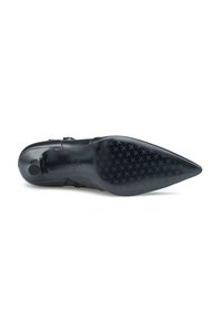 Scarpa nera in pelle con tacco alto e punta affusolata. Presenta una suola in gomma testurizzata con una presa a motivo e un dettaglio con fibbia sul lato.