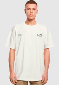 Hvid kortærmet bomulds t-shirt, med tekst p�å forsiden herunder "LIFE" og et citat på venstre side i sort tryk.