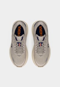 Ζευγάρι ανοιχτόχρωμων γκρι παπουτσιών τρεξίματος Hoka με μπλε ναυτικό και πορτοκαλί λεπτομέρειες, απεικονιζόμενα από πάνω σε λευκό φόντο.