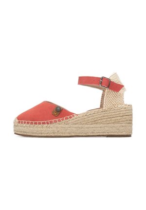 Sandalia de esparto de ante coral con correa en el tobillo, parte trasera tejida y suela de cuña de yute. Cuenta con un logo decorativo en el lateral.