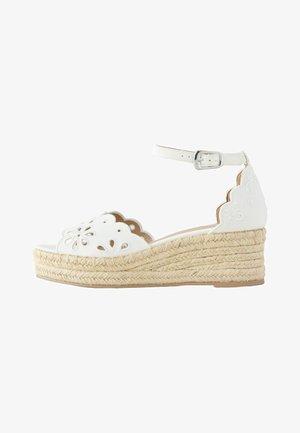 Baltos pleišto formos espadrilių basutės su kulkšnies dirželiu, banguotais kraštais, gėlių išpjovų dizainu ir austu jūžės platformos padu.