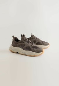 Brown suede and mesh sneakers with a chunky beige sole. Features lace-up design, padding on the collar, and a contrasting rubber outsole.