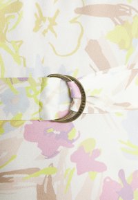 Bloemenstof, zachte textiel met pasteltinten (roze, geel, groen) met een ronde metalen gesp met de inscriptie "Ted Baker".