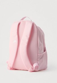 Ροζ σακίδιο πλάτης με υφή από δίχτυ μπροστά, επενδεδυμένους ιμάντες και πλαϊνή τσέπη. Διαθέτει λευκό λογότυπο και λεία, ανθεκτική υλική επιφάνεια.
