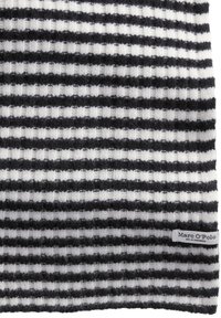 Dziany szalik z naprzemiennymi czarno-białymi paskami, z teksturowanym wzorem. Mała metka w dolnym rogu z napisem "Marc O'Polo".