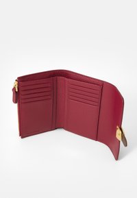 Red leather wallet with a textured finish, featuring multiple card slots, a zippered compartment, and gold hardware accents.