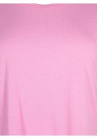 Lyserød kortærmet t-shirt lavet af blødt stof. Enkel rund hals; glat overflade uden synlige mønstre eller detaljer.