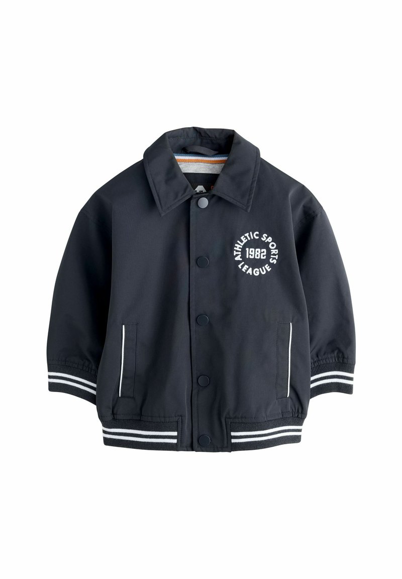 Chaqueta azul marino con cuello, botones frontales, rayas blancas en las mangas y un logotipo que dice "Liga Deportiva Atlética 1982".