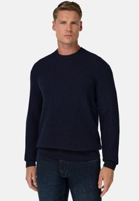 Maglione lavorato a maglia blu navy con texture a costine, scollatura tonda e maniche lunghe; presenta una vestibilità rilassata e polsini e orlo elasticizzati.