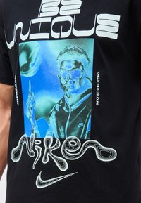 Γραφικό με ένα άτομο που φοράει γυαλιά ηλίου και κουκούλα Nike με στιλιζαρισμένο κείμενο "unique" και "nike" σε μαύρο μπλουζάκι.
