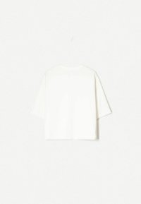T-shirt bianco in cotone con design boxy, maniche corte e scollatura rotonda. Texture liscia con dettagli di cucitura minimi sul retro.