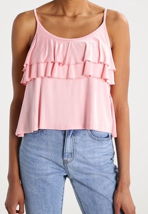 Pink sleeveless top with ruffled tiers, made of soft fabric, featuring a relaxed fit and round neckline, worn with light blue jeans.