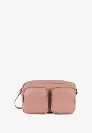 Pink leather crossbody bag with two front zippered square pockets and adjustable strap on white background.