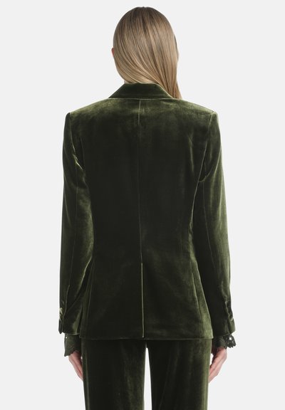 Tamnozeleni baršunasti sako s elegantnim dizajnom, s oštrim reverima, jednim prorezom straga i čipkastim detaljima na manžetama. Glatka tekstura i kroj prilagođen figuri.