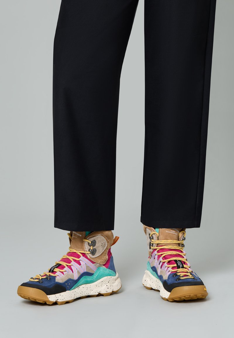 Sneakers alte multicolori con un mix di texture, caratterizzati da una suola maculata, pannelli in tessuto vivaci e lacci e dettagli a contrasto.