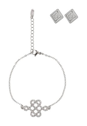 Brățară argintie cu un design complex de nod și cercei cu diamante pătrați asortați, pe un fundal alb.