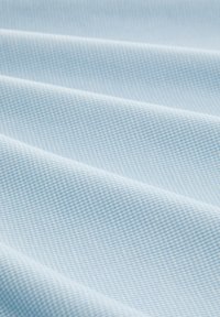 Tela de color azul claro con un fino patrón de cuadrícula, de textura suave y caída fluida, que muestra variaciones sutiles en el tono y un ligero brillo.