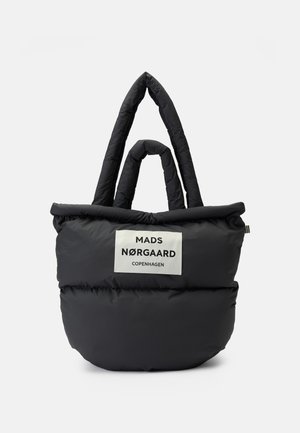 Czarna pikowana torba typu tote z dwoma zestawami uchwytów, z białą etykietą z napisem "Mads Nørgaard Copenhagen" z przodu.