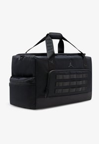 Μαύρη τσάντα duffle με υφή, εξοπλισμένη με φερμουάρ στην κορυφή, διπλές λαβές και μπροστινή τσέπη με ιμάντες webbing για επιπλέον αποθηκευτικό χώρο.