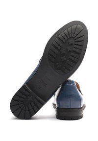 Scarpa di pelle blu con una forma distintiva, tomaia testurizzata e suola in gomma nera robusta con diversi motivi antiscivolo.