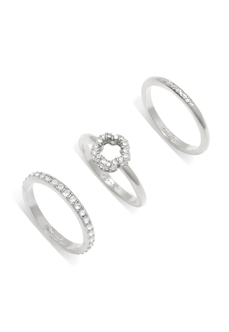 Drei silberne Ringe: einer mit einer Reihe kleiner klarer Steine, ein zweiter mit einem runden Steincluster und ein dritter mit einem filigranen Design.