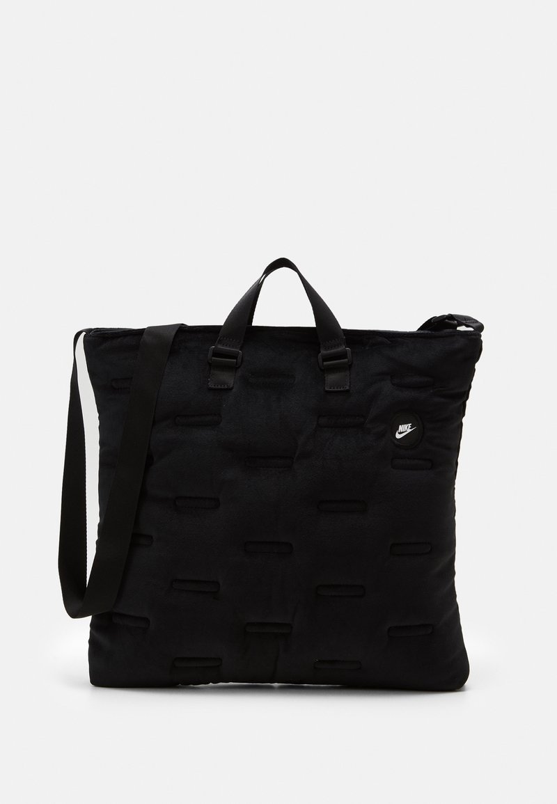 Sac fourre-tout rectangulaire noir de Nike avec poignées courtes, bandoulière ajustable et détails subtilement matelassés horizontaux sur la surface du tissu.