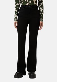 Černé vysoké zvonové džíny z denimu se zapínáním na knoflík, předními kapsami a hladkou texturou. Doplňují je minimalistický design.