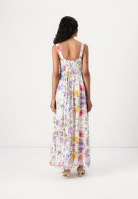 Maxiklänning i lätt tyg med ett färgglatt blommönster. Har smockad baksida, breda axelband och en flödande silhuett.