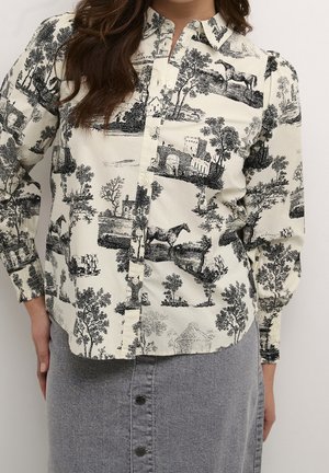 Knappet cremefarvet skjorte med sorte sceniske print af heste, træer og bygninger kombineret med en høj taljet grå nederdel med knapper.
