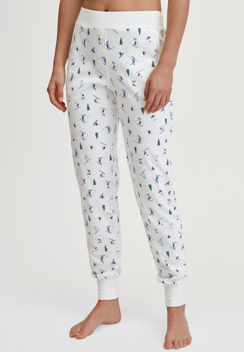 Pantalons de lounge en coton avec une base blanche, décorés d'un motif de skieurs et d'arbres en bleu et vert. Taille élastique et chevilles resserrées.
