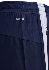 Pantalones cortos deportivos de color navy con textura de malla, cinturilla elástica, franjas blancas a los lados y un pequeño logo "BEECOOL" cerca de la cintura.