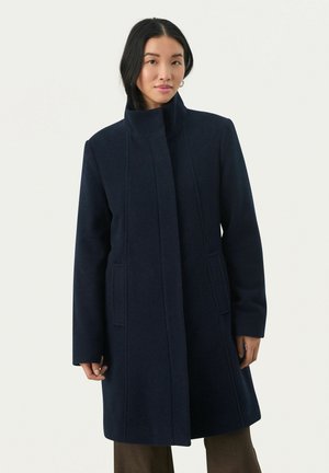 Marinblå ullkappa med hög krage, långa ärmar och sidofickor, med en ren design och minimal detaljering.