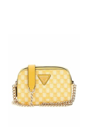 Sac bandoulière jaune à carreaux avec bandoulière chaîne dorée et logo Guess sur le devant, forme rectangulaire avec fermeture éclair en haut.