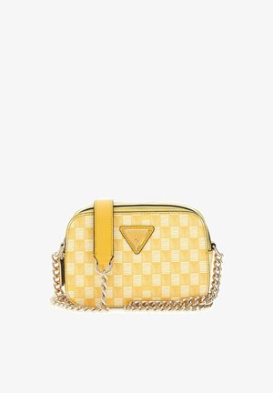 Sac bandoulière jaune à carreaux avec bandoulière chaîne dorée et logo Guess sur le devant, forme rectangulaire avec fermeture éclair en haut.