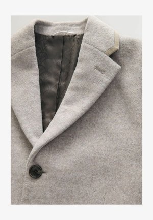Szürke gyapjú keverék kabát, notch gallérral, egy gombos záródással és sima mintás béléssel. Finom textúrájú és testhez simuló fazonnal rendelkezik.