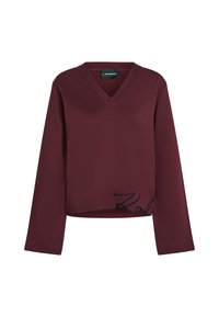 Maglietta bordeaux a maniche lunghe con scollo a V, caratterizzata da una scritta nera ricamata lungo l'orlo. Tessuto morbido e strutturato con un fit rilassato.